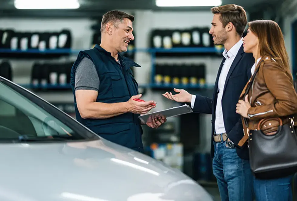 Asesor conversando con clientes en un negocio automotriz