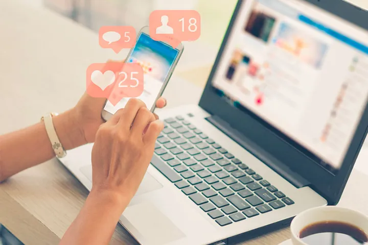 Uso de redes sociales desde un teléfono y una computadora